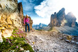 © Michael - Young athletic woman walks on via ferrata trail with scenic view on Tre Cime in the evening. Tre Cime, Dolomites, South Tirol, Italy, Europe.