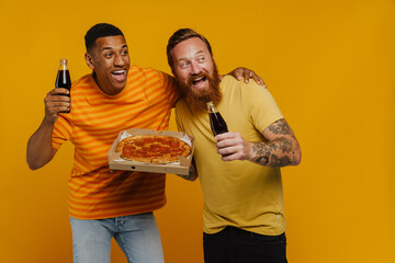 Canvas Print - Two happy men holding pizza and glass bottle soda looking aside