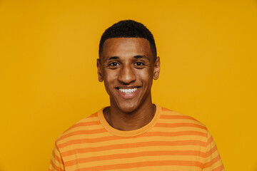 Young brunette man in t-shirt looking and smiling at camera