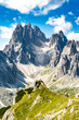© Michael - Athletic woman walks on super epic view point with Cadini group in the morning. Tre Cime, Dolomites, South Tirol, Italy, Europe.