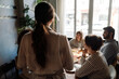 © Drobot Dean - Back view of young waitress serving group of friends in restaurant