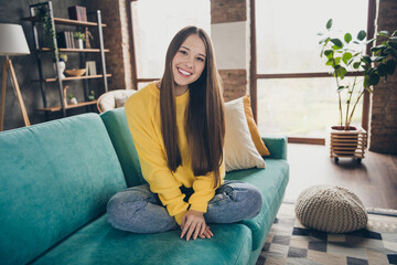 Wall Mural - Full body photo of satisfied glad carefree person sitting cozy couch have good mood toothy smile free time flat inside