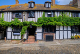 Fototapeta Tulipany - Rye, East Sussex, England, Europe - May 18, 2023: The Mermaid - ancient hotel on a cobblestoned street. A small English medieval coastal town on a sunny day.
