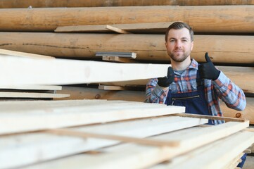 Wall Mural - Male Worker folds boards. Sawmill. Wood harvesting process