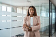 © insta_photos - Confident proud young professional business woman ceo, female corporate executive leader, African American lady lawyer wearing suit standing arms crossed in office near glass wall, portrait.
