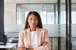 © insta_photos - Confident smiling young professional business woman ceo corporate leader, female African American lawyer or leader manager wearing suit standing arms crossed in office, headshot portrait.