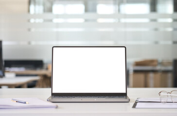Laptop device mock up template design on office workplace desk, white mockup empty blank computer screen on office work table business web technology at modern workspace, closeup.
