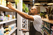 © ADDICTIVE STOCK - Focused black man with tablet checking goods in cosmetic shop