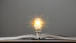 Glowing light bulb with creativity twinkling lights on a book. Ideas for inspiration from reading. Innovation concept of self-learning, education knowledge, technology, business, power of knowledge.