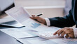 © Witoon - Close up work of businessman or accountant using calculator and laptop while analyzing business report in workplace financial planning and accounting concept
