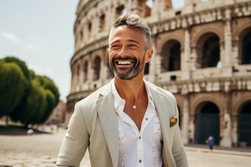 Wall Mural - Handsome young man in shirt and jacket smiling while standing in front of Colosseum in Rome, Italy