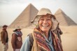 © Anne Schaum - Portrait of happy senior woman in front of pyramids in Giza, Egypt
