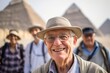 Portrait of smiling senior man with tourists in background at Giza, Egypt