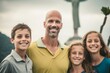 © Anne Schaum - Portrait of smiling father with his kids in the park on a cloudy day
