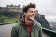 © Anne Schaum - Lifestyle portrait photography of a grinning man in his 20s that is smiling with friends at the Edinburgh Castle in Edinburgh Scotland . Generative AI