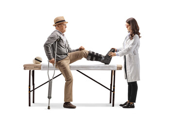 Sticker - Elderly man with a leg brace sitting on a bed and a female doctor checking his foot