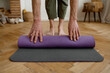 © Nomad_Soul - Fitness man folding exercise mat before yoga working out at home