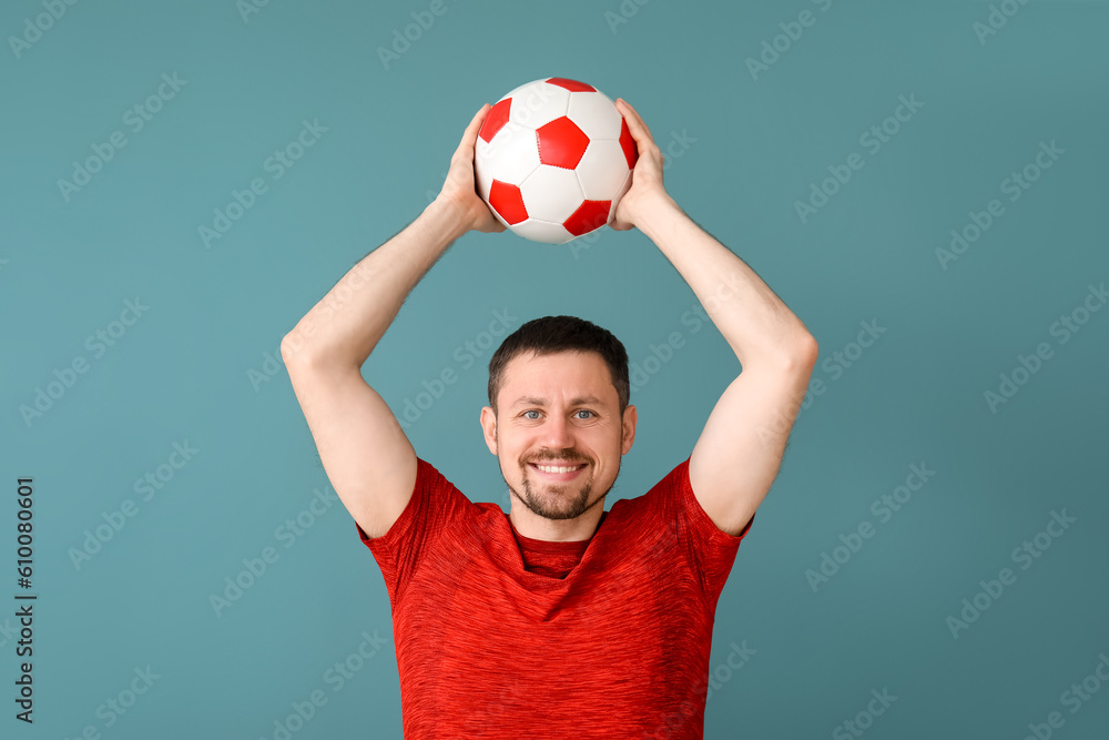 Happy man with soccer ball on blue background