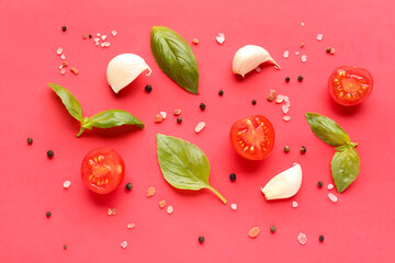 Composition with ripe cherry tomatoes, basil leaves, garlic and peppercorn on red background