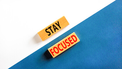 Stay focused symbol. Concept words Stay focused on wooden blocks on a beautiful white and blue background. Business, support, motivation, psychological and stay focused concept. Copy space.