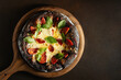 Black pizza margarita with tomatoes, mozzarella and basil. Dough with healthy bamboo charcoal powder, copy space