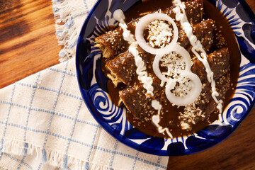 Wall Mural - Enchiladas de Mole. Also known as mole poblano enchiladas, they are a typical Mexican dish that is very popular in Mexico and the rest of the world.