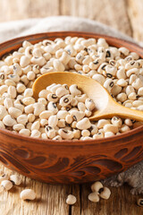 Poster - Raw Organic Black Eyed Peas close-up in a bowl on a wooden table. Vertical