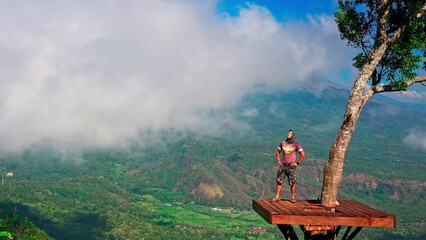 Wall Mural - Silhouette active lifestyle travel people standing on the top scenery view point above the clouds on background majestic volcano Gunung Agung Bali, Indonesia 4K 