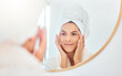 © Courtney Haas/peopleimages.com - Mirror, woman and hands on face for skincare, check and anti aging cosmetic results in bathroom. Facial, beauty and female touching soft, glow and smooth skin after luxury dermatology routine at home