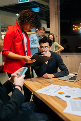 Wall Mural - Vertical shot of serous young businessman reading document at meeting. Caucasian male entrepreneur considering contract. Company ceo analyzing report. Hr manager holding applicants cv resume.