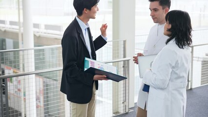 Poster - A multinational group having a conversation in the lobby.
People in white coats and sales staff.