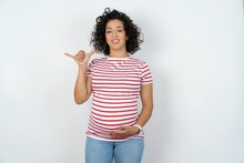 Young Pregnant Woman Wearing Striped T-shirt Over White Background Showing Up Number Six Liu With Fingers Gesture In Sign Chinese Language