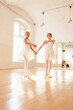 © carlesmiro - Smiting teenage ballet dancers rehearsing together in bright dance studio and looking at camera.