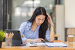 © David - Portrait of tired young business Asian woman work with documents tax laptop computer in office. Sad, unhappy, Worried, Depression, or employee life stress concept