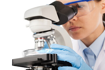 Wall Mural - young scientist doing research and looking through a microscope in a laboratory.