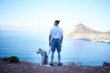 Nature, lake and man with dog in mountain for hiking, walking and fresh air together outdoors. Traveling, friendship and back of male person with pet husky relax for freedom, adventure and exercise