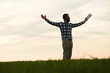 © standret - Enjoying freedom, with hands up. Handsome young man is on agricultural field