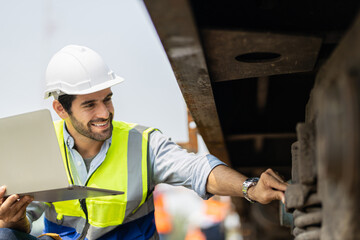 Mechanical engineer or professional maintenance technician wearing safety clothing is using a wrench to repair and inspect the undercarriage of the train, have double exposure images, and bokeh.