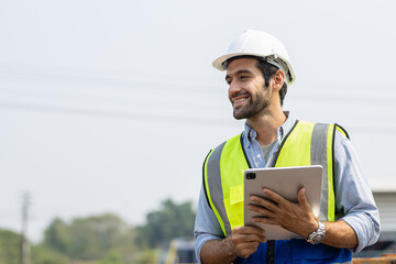 Heavy-duty industrial engineers stand in a pipeline manufacturing facility using digital tablet computers for the construction of products to transport oil, gas and fuel.