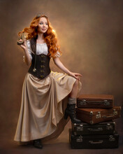 Red-haired Girl In A Steampunk Outfit With Vintage Suitcases