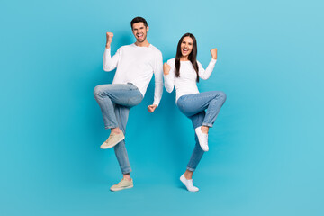 Full length photo of two delighted crazy people raise fists luck accomplishment isolated on blue color background