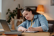 © AnnaStills - Girl with down syndrome making notes during online lesson while sitting at desk in front of laptop