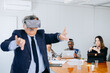 © jaimelafrickmartial  - Adult businessman showing young people in his company how to use VR glasses.