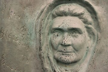 Wall Mural - A statue of the face of a concerned woman.