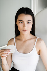 girl with acne stick round acne patch in hands. using acne patches for treatment of pimple and rosac