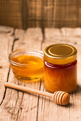 Wall Mural - Honey in bowl, dipper on an aged wooden background.