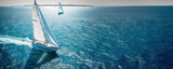 Regatta of sailing ships with white sails on the high seas. Aerial view of a sailboat in a windy state.