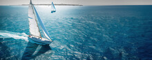 Regatta Of Sailing Ships With White Sails On The High Seas. Aerial View Of A Sailboat In A Windy State.