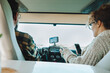 © simona - Inside back view of vehicle cabin like motorhome and couple traveling and using gps navigation system and phone to plan road trip and destination. Concept of camper van vacation adventure tourism