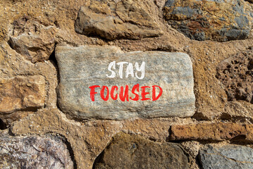 Stay focused symbol. Concept words Stay focused on beautiful stone on a beautiful stone wall background. Business, support, motivation, psychological and stay focused concept. Copy space.